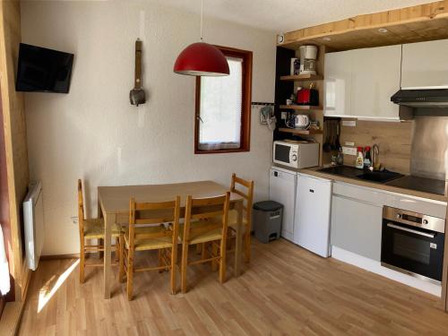 une cuisine avec une table et des chaises dans une pièce dans l'établissement Appartement chaleureux 4 pers, proche des remontées et commerces, balcon ensoleillé - FR-1-263-520, à Valloire