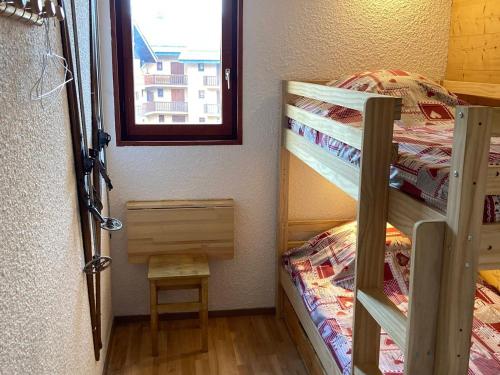 une petite chambre avec deux lits superposés et une fenêtre dans l'établissement Appartement chaleureux 4 pers, proche des remontées et commerces, balcon ensoleillé - FR-1-263-520, à Valloire