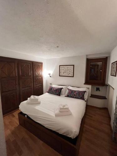 1 dormitorio con 1 cama grande con sábanas y almohadas blancas en refuge du skieur cir 0051 en Courmayeur