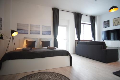 ein Schlafzimmer mit einem großen Bett und einem Sofa in der Unterkunft ☆Nostalgie Apartment I Innenstadt I Smart TV I Küche in Kaiserslautern