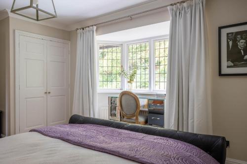 a bedroom with a bed and a window and a desk at Riverbank house - Cookham in Cookham