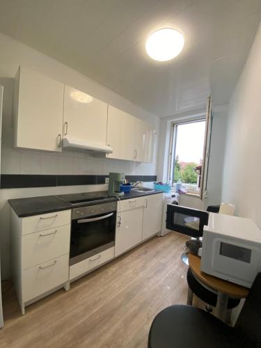 a kitchen with white cabinets and a stove top oven at Annie´s Appartements in Mannheim