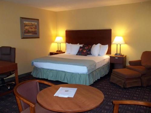 Pokój hotelowy z łóżkiem, krzesłem i stołem w obiekcie Southern Inn & Suites RV Lots now available w mieście Yorktown