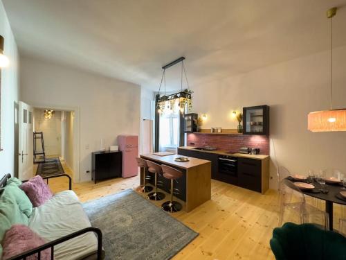 een woonkamer met een bank en een keuken met een tafel bij Urban Jungle! in Berlijn