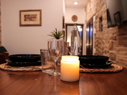 une table avec une bougie, des assiettes et des verres dans l'établissement CASA ARMANNI - la tua Casa di Pietra, à Gubbio