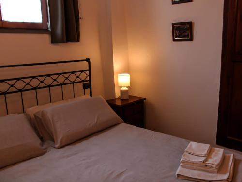 una camera da letto con un letto con una lampada e una finestra di CASA ARMANNI - la tua Casa di Pietra a Gubbio