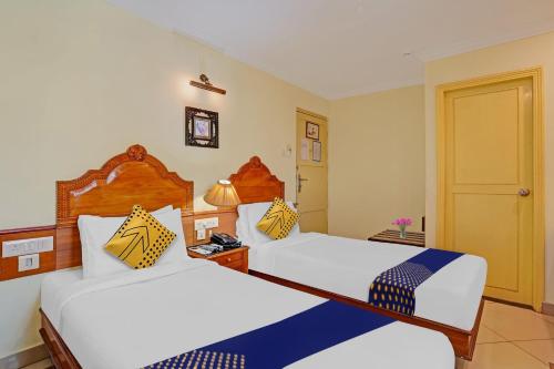 a hotel room with two beds and a door at Super Capital O Indrapuri Rajadhani in Trivandrum