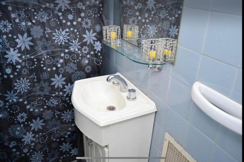 uma casa de banho com um lavatório branco e azulejos azuis em Don Pablo em Buenos Aires