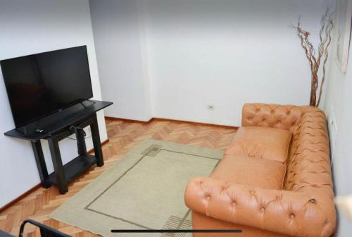 uma sala de estar com um sofá e uma televisão de ecrã plano em Don Pablo em Buenos Aires