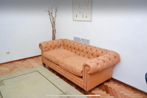 um sofá de couro castanho sentado num quarto em Don Pablo em Buenos Aires
