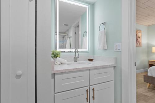 een witte badkamer met een wastafel en een spiegel bij The Coral Reef - L in Siesta Key