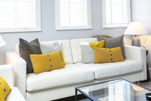 a living room with a white couch with yellow pillows at Station Inn Pawling in Pawling