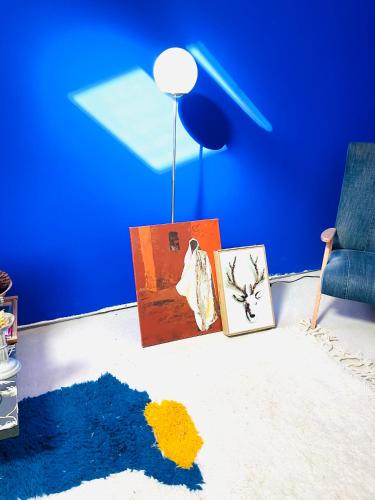 a blue room with two pictures and a chair at Le loft design st Armand in Salles