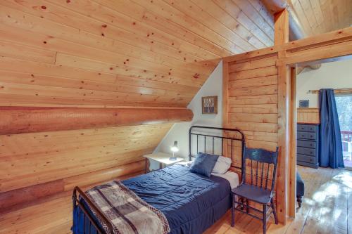 a bedroom in a log cabin with a bed and a chair at The InnLet - Comfy Cabin By Conkling Marina in Worley