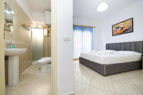 ein Bad mit einem Bett, einem WC und einem Waschbecken in der Unterkunft Noa Apartments in Vlorë