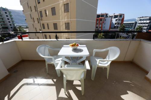 a white table and chairs on a balcony at Noa Apartments in Vlorë