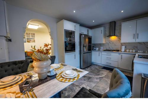 una cocina con una mesa con un jarrón. en UPPAMOST LUXURY HOME LONDOn, en Dagenham