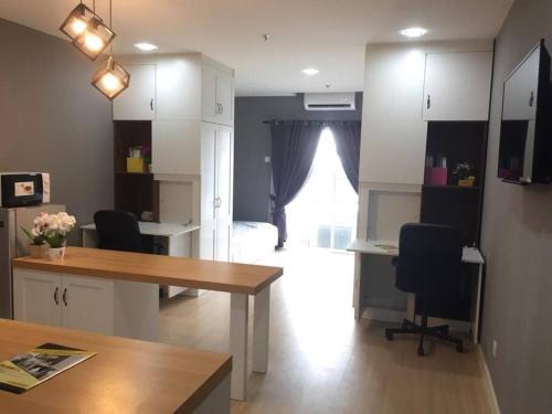 a room with a desk and two chairs and a bedroom at Champs Elysees by Landmark @ Kampar in Kampong Malim Nawar