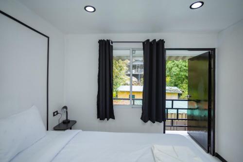 a bedroom with a mirror and a window at The Bright House, Koh Phi Phi in Phi Phi Don