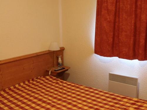 モダーヌにあるAppartement Modane, 2 pièces, 4 personnes - FR-1-265-114のベッドルーム1室(チェック入りの毛布付きのベッド1台付)
