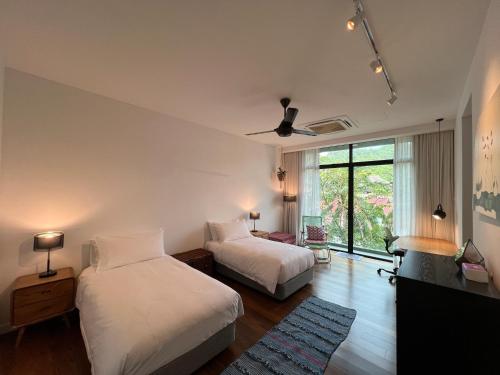 a bedroom with two beds and a ceiling fan at Malibu Langkawi Private Pool Villa in Pantai Cenang