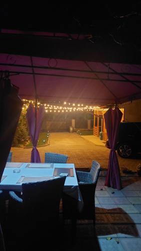 a table and chairs under a tent with lights at Pensiunea Happy Flowers in Greci