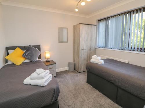 1 dormitorio con 2 camas y ventana en The Croft, North Staffordshire en Stoke on Trent