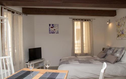 - une chambre avec un lit et une table avec des verres à vin dans l'établissement Gîte les iris, à LʼIsle-sur-la-Sorgue