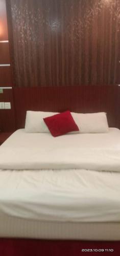 a bed with a red pillow on top of it at Hotel ABC Pvt. Ltd. in Bhairahawa