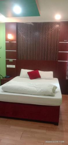 a bedroom with a large bed with a red pillow at Hotel ABC Pvt. Ltd. in Bhairahawa