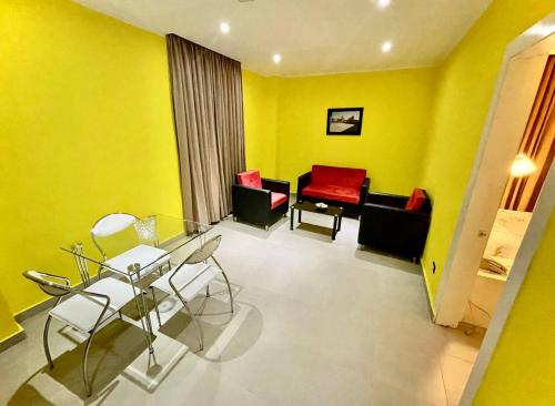 a yellow living room with a glass table and chairs at LA VlTA E' BELLA in Los Mameyes