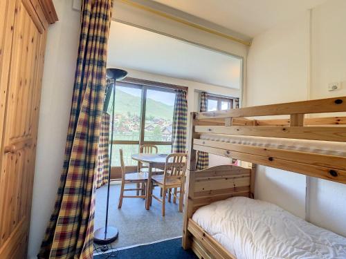 une chambre avec un lit superposé et une table dans l'établissement Charmant studio balcon nord, proche commerces et pistes, résidence avec ascenseur - Fontcouverte - FR-1-417-14, à La Toussuire