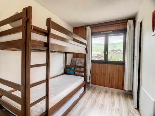 une chambre avec deux lits superposés et une fenêtre dans l'établissement Appartement rénové à 50m des pistes, balcon Est, 2 étoiles, 5 pers. - FR-1-417-24, à La Toussuire
