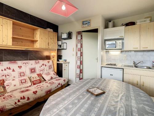 Cette petite chambre comprend un lit et une cuisine. dans l'établissement Appartement cosy 4 pers avec balcon sud à La Toussuire, proche commerces et pistes - FR-1-417-29, à La Toussuire