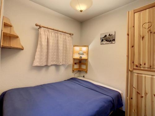 ラ・トゥッスイールにあるAppartement La Toussuire, 2 pièces, 4 personnes - FR-1-417-29のベッドルーム(青いベッド1台、窓付)