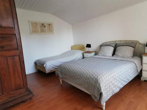 une chambre avec deux lits et un parquet dans l'établissement Villa Le Nid proche plage, à Saint-Palais-sur-Mer