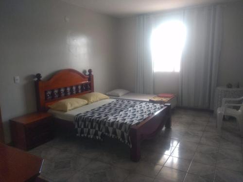 a bedroom with a bed in a room with a window at Hospedaria Chaves in Brasília