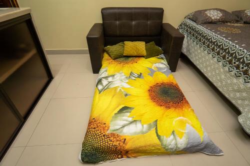 a bedroom with a bed with a sunflower blanket at Apartamento Aliga 2 in Quepos