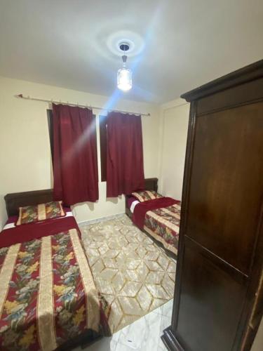a bedroom with two beds and red curtains at Riad salam agadir in Agadir