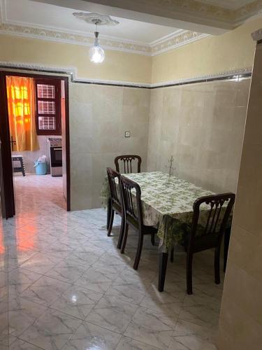 Riad salam agadir في أغادير: غرفة طعام مع طاولة وكراسي وغرفة بها