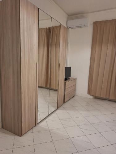 a room with wooden doors and a television and a mirror at Giada Apartment in Calenzano