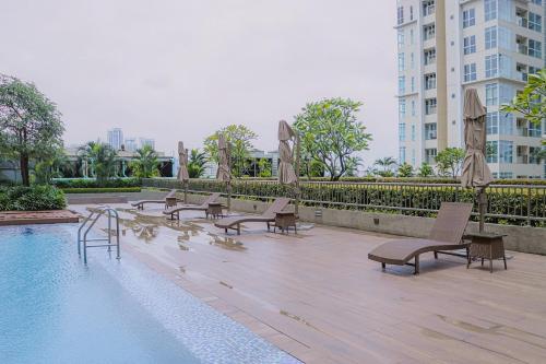 マニラにあるHomey 1Bedroom BGC Condo - MINIMUM 2 Nights stayの- 建物の隣のプール(長椅子、椅子付)