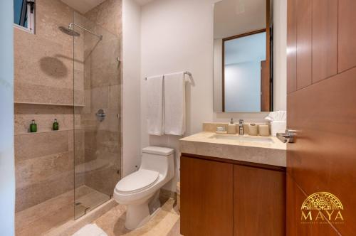 ein Badezimmer mit Toilette, Waschbecken und Dusche in der Unterkunft NHOA 209A Lux 2BR Condo Pool View in Aldea Zama in Tulum