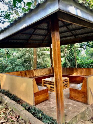 a wooden gazebo with benches under it at The Address Resort in Kalangala