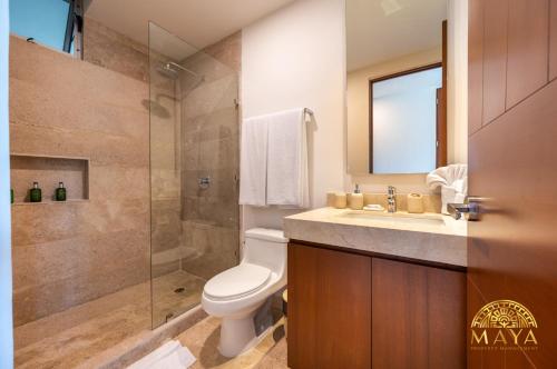 トゥルムにあるNHOA 305A Lux 2BR Condo Pool View in Aldea Zamaのトイレ、洗面台、シャワー付きのバスルーム