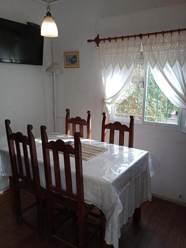 una sala da pranzo con tavolo, sedie e una finestra di Vivienda en altos con uso exclusivo de entrada de auto y parrilla a Miramar