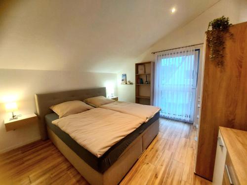 a bedroom with a large bed and a large window at Ferienwohnung Waldliebe in Homburg