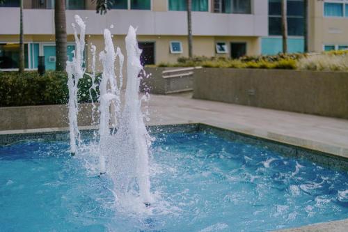 a fountain in a pool in front of a building at Homey 1Bedroom BGC Condo - MINIMUM 2 Nights stay in Manila