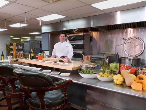 a chef standing behind a counter in a kitchen at The Brown Hotel in Louisville