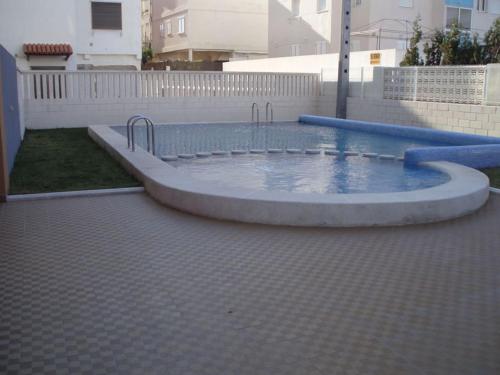 ein Schwimmbad in der Mitte eines Gartens in der Unterkunft Apartamento a 100 metros del mar in Piles